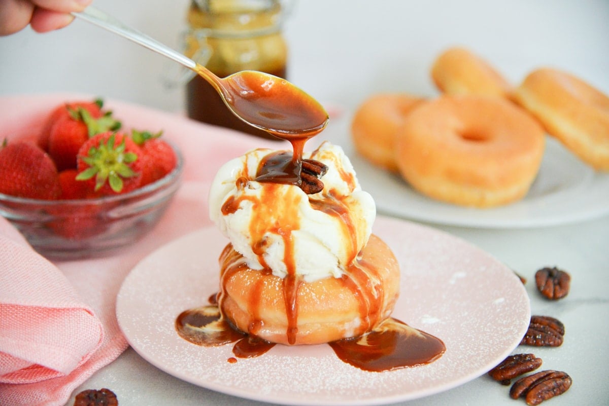 spooning bourbon caramel sauce over ice cream 