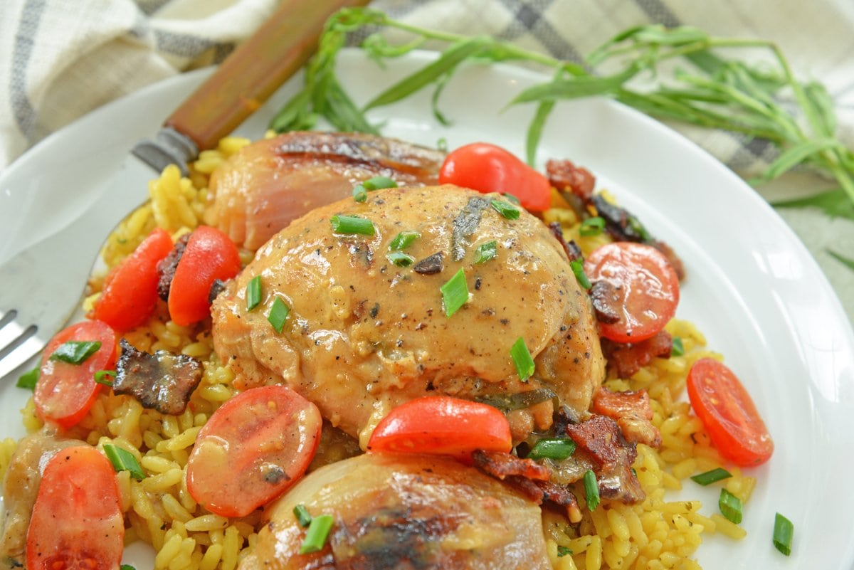 close up of chicken thigh with white wine dijon sauce with tomatoes and chives 