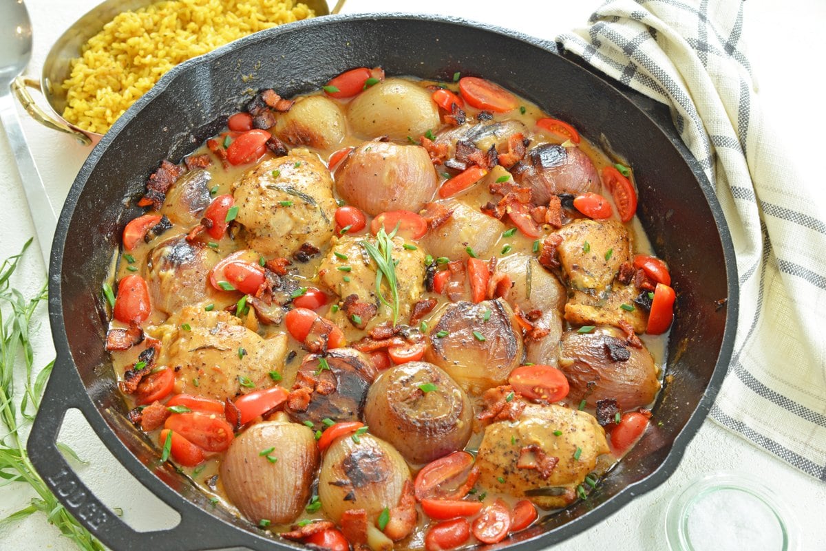 overhead skillet of chicken thighs with tomatoes and gravy sauce