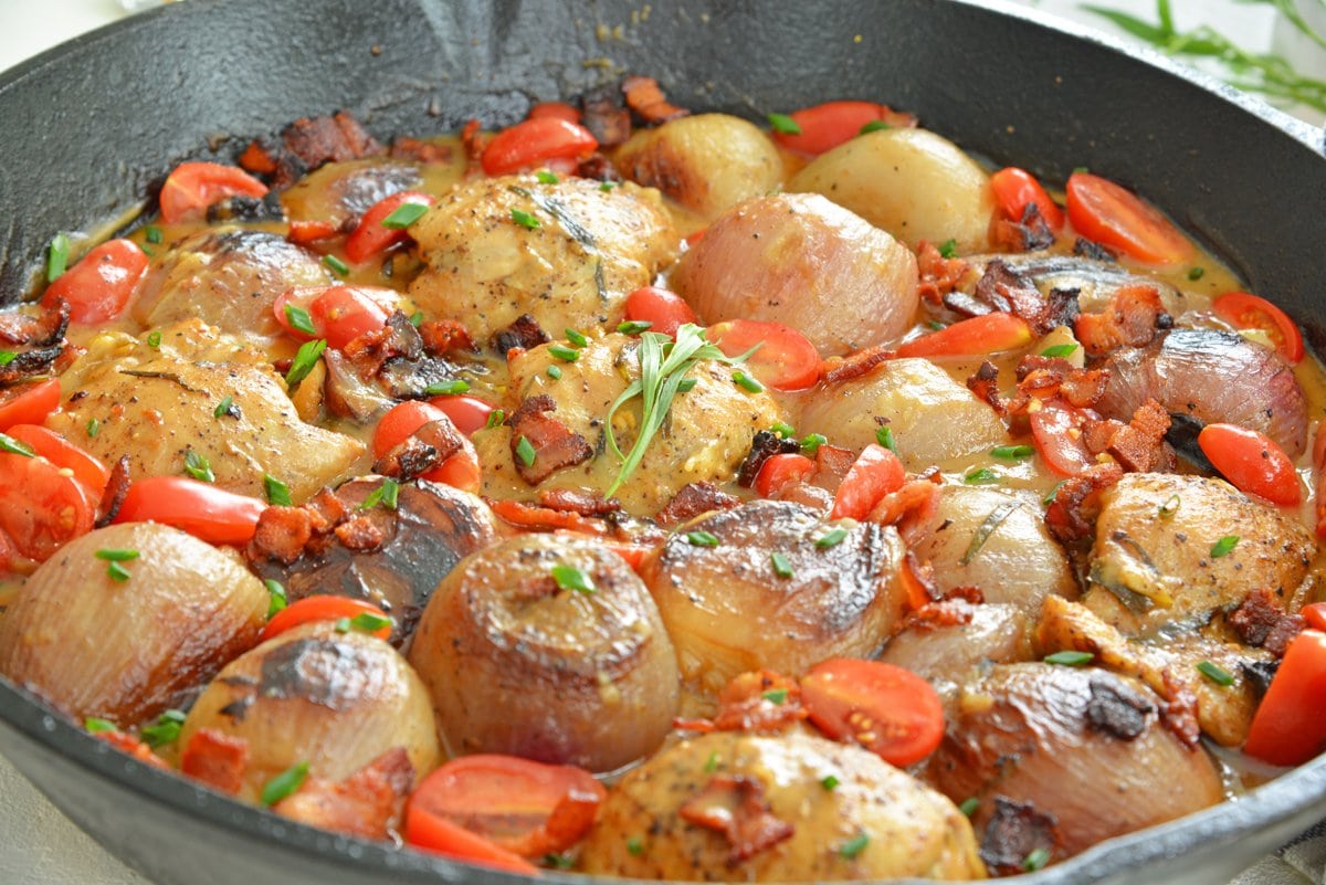 angle view of braised chicken thighs in cast iron skillet