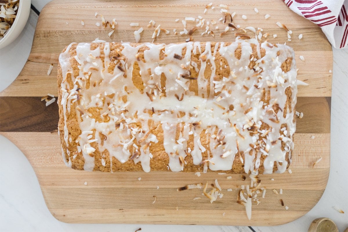 overhead of loaf of coconut pound cake with toasted coconut topping and glaze 