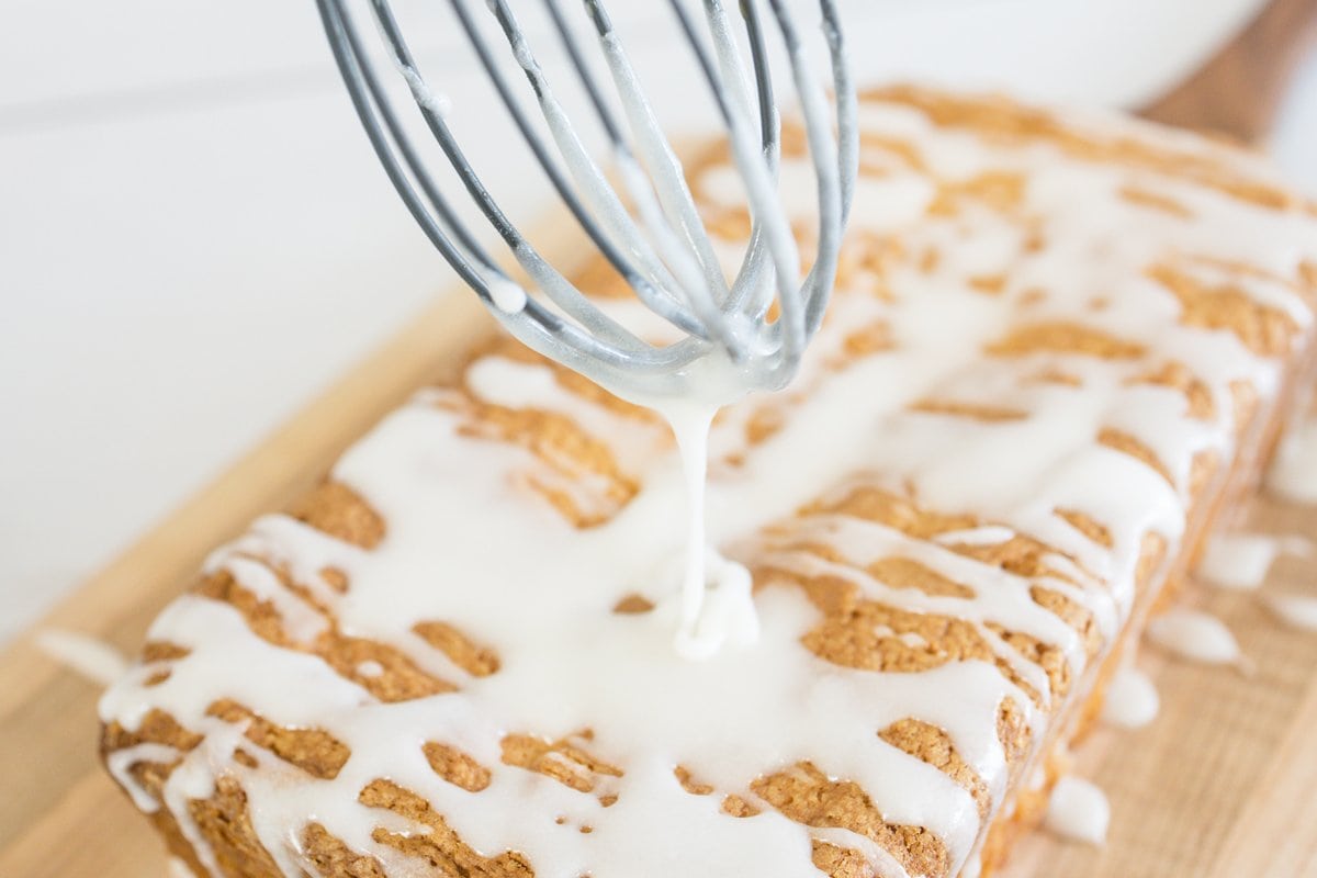 whisk drizzling glaze onto pound cake loaf 