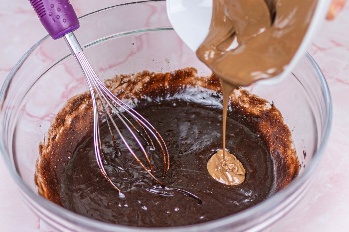 pouring chocolate into brownie batter 