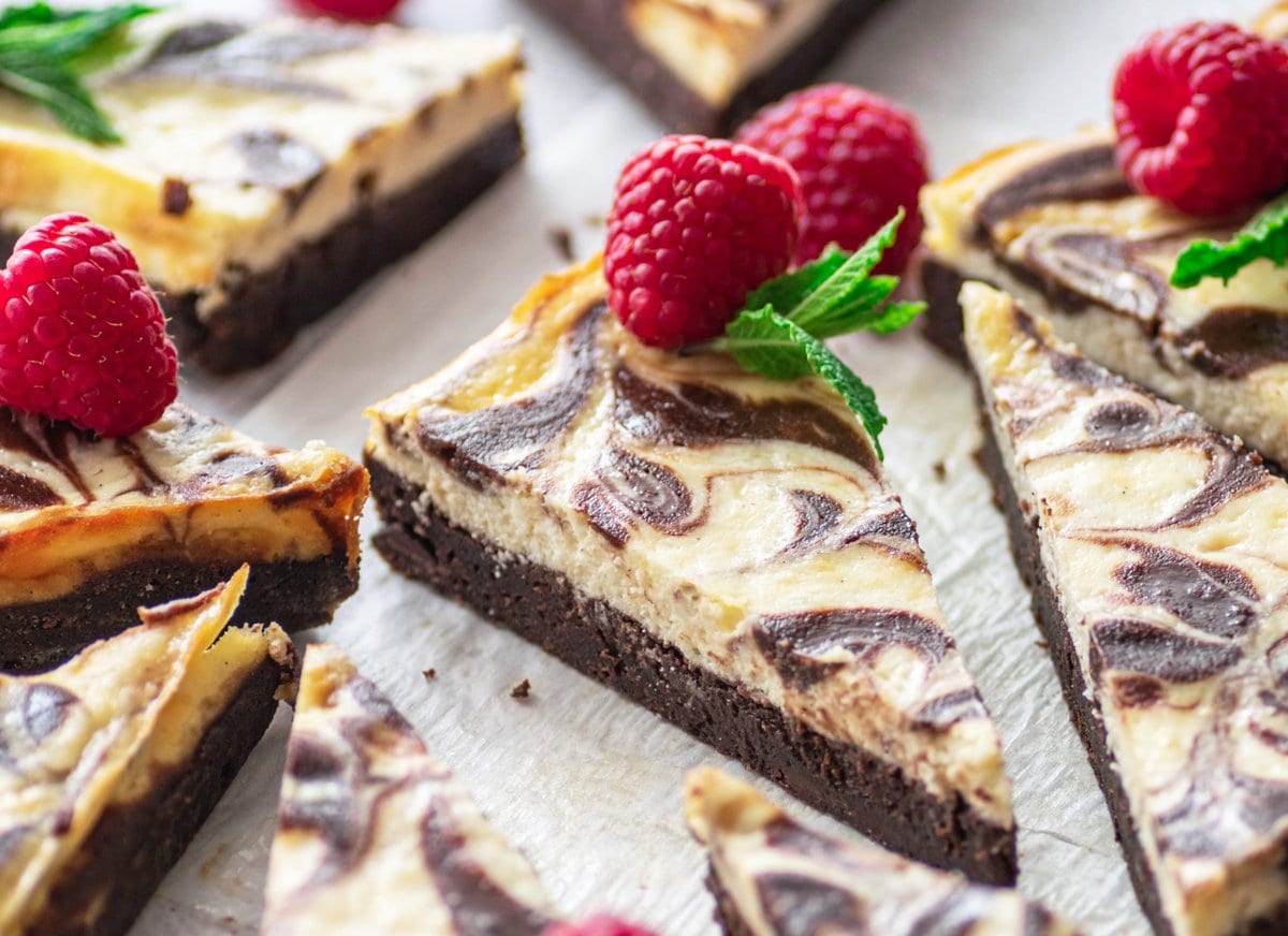 close up angle of cut brownies with a raspberry 