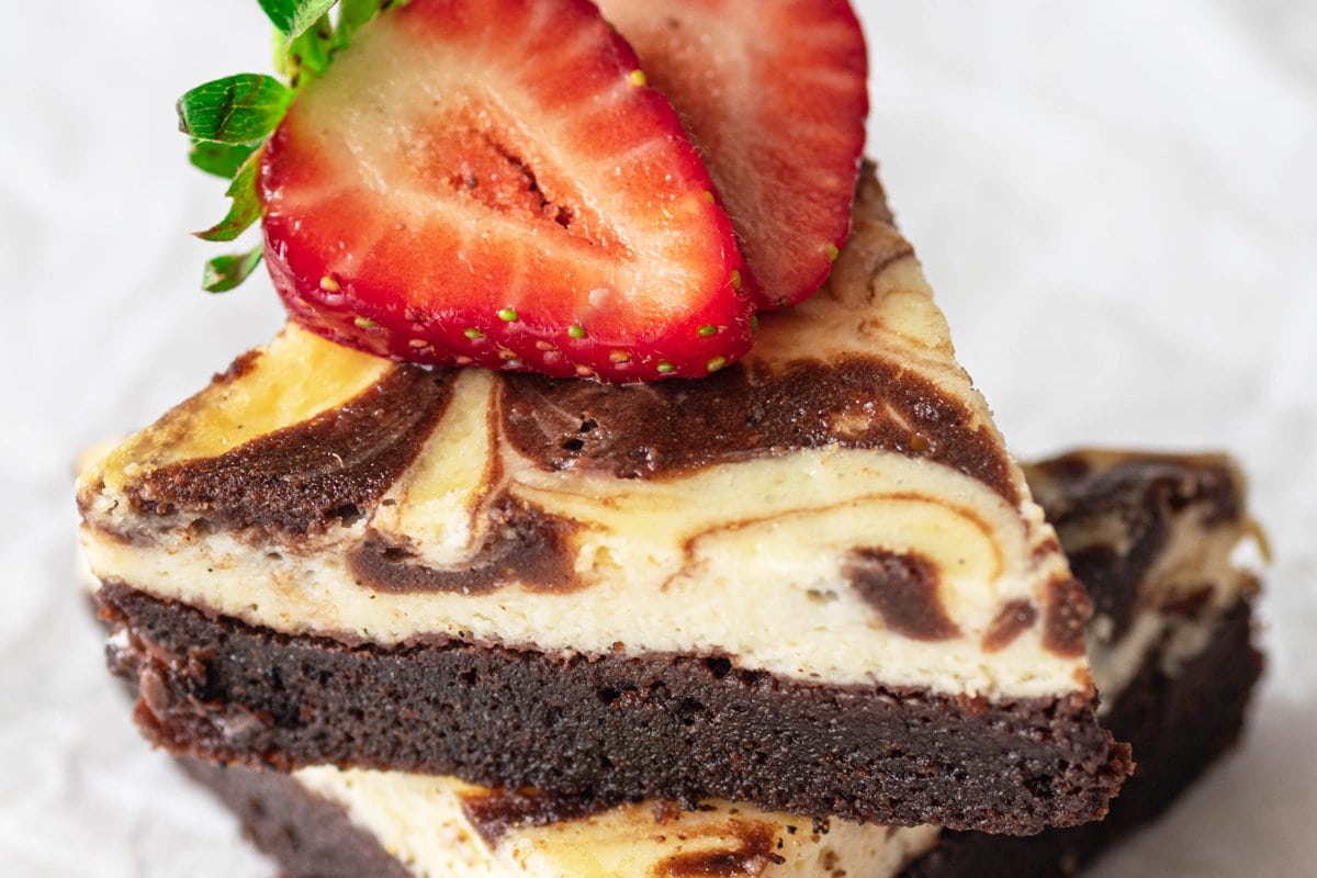 close up of cut brownies with a strawberry on top 