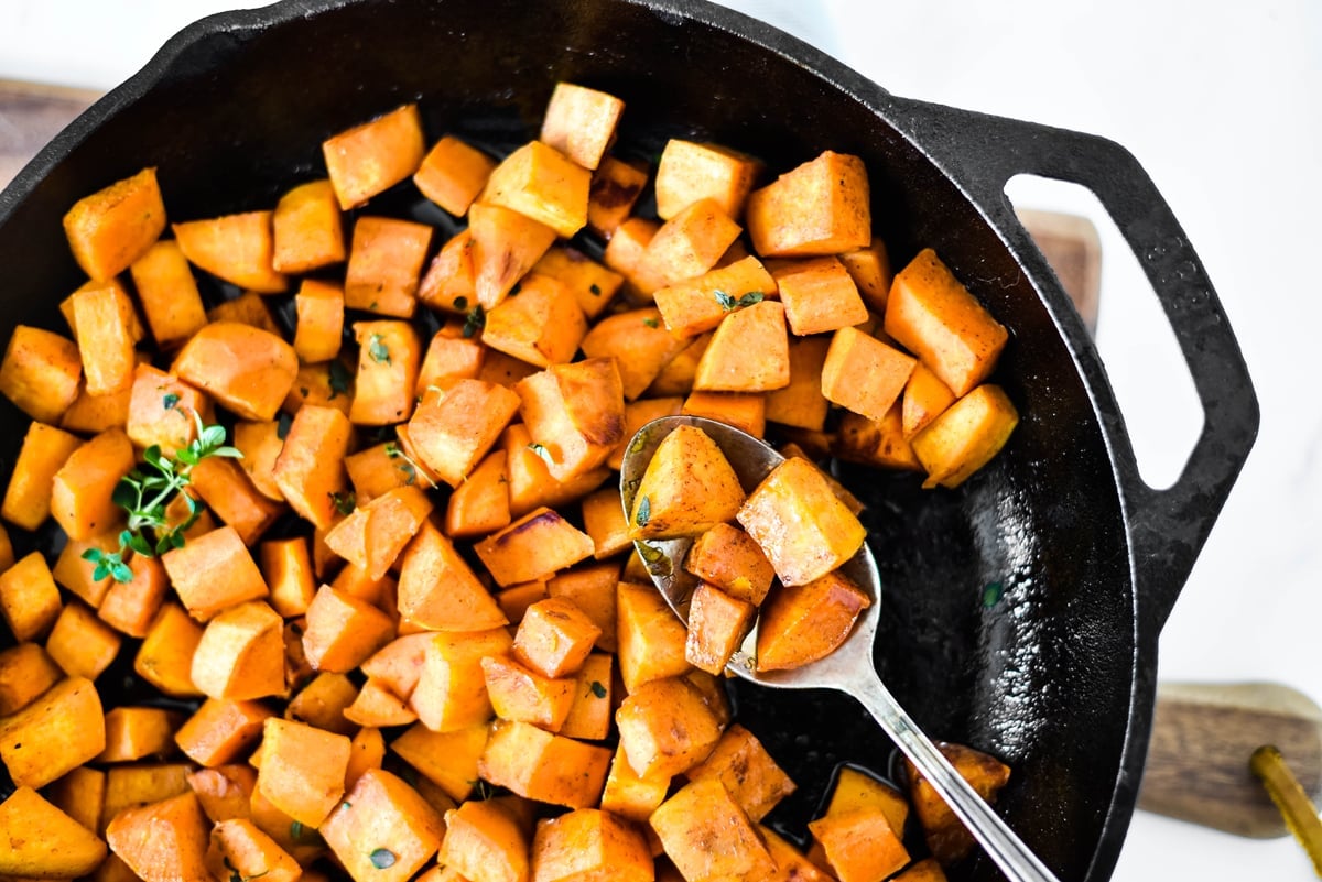 spoon in sweet potatoes in a skillet 