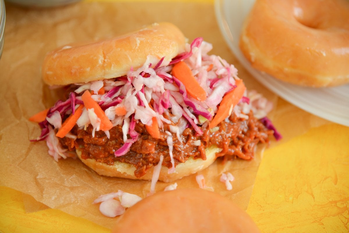 side view of pulled pork sandwich on a glazed donut 