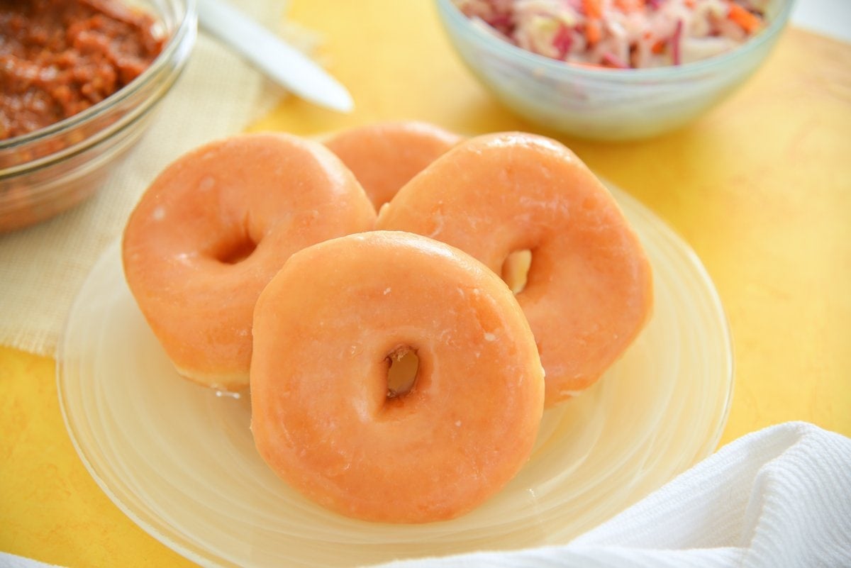glazed yeast donuts on a glass plate 