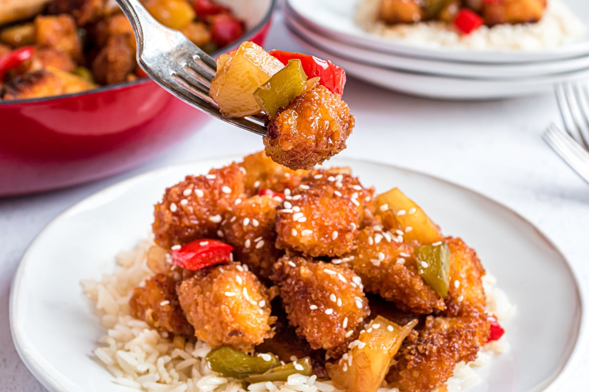 fork holding sweet and sour chicken pieces 