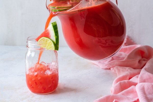 pitcher pouring vodka watermelon cocktail into glass