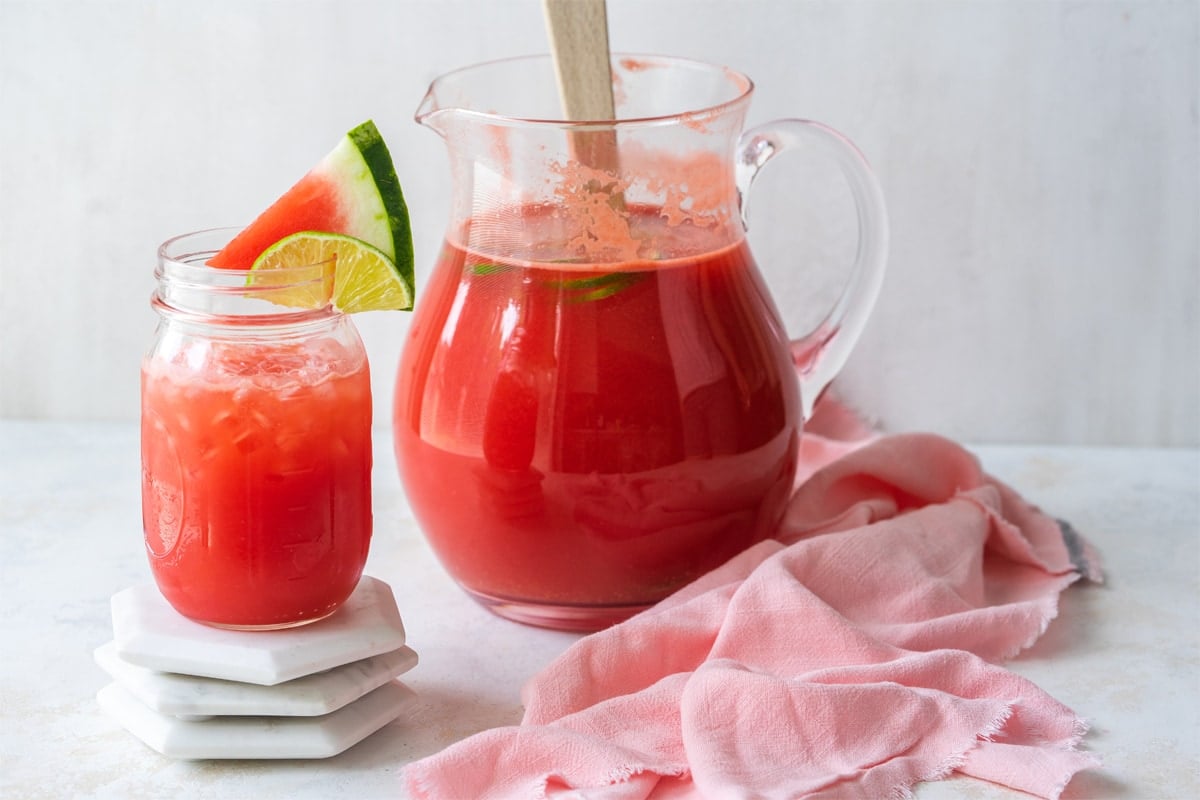 glass of vodka watermelon cocktail next to pitcher