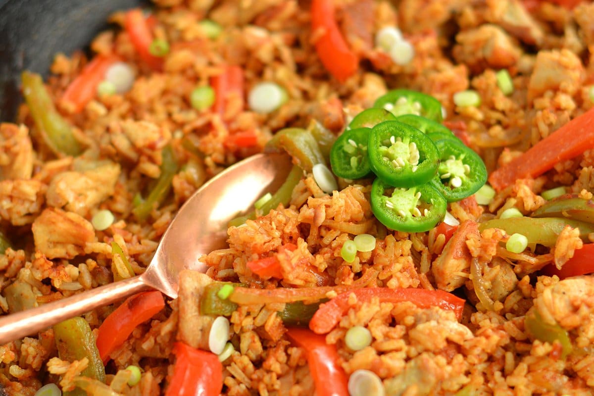 close up of spoon digging into chicken and rice skillet 