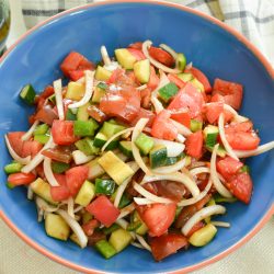 overhead of cucumber tomato salad recipe in a blue bowl