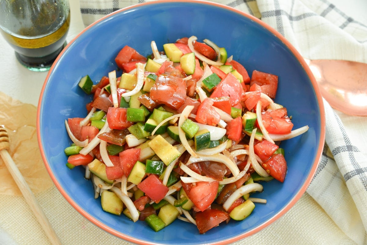 overhead of cucumber tomato salad recipe in a blue bowl