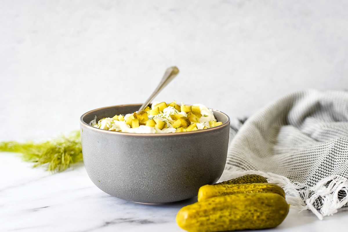 side view of dill pickle dip in a gray bowl  