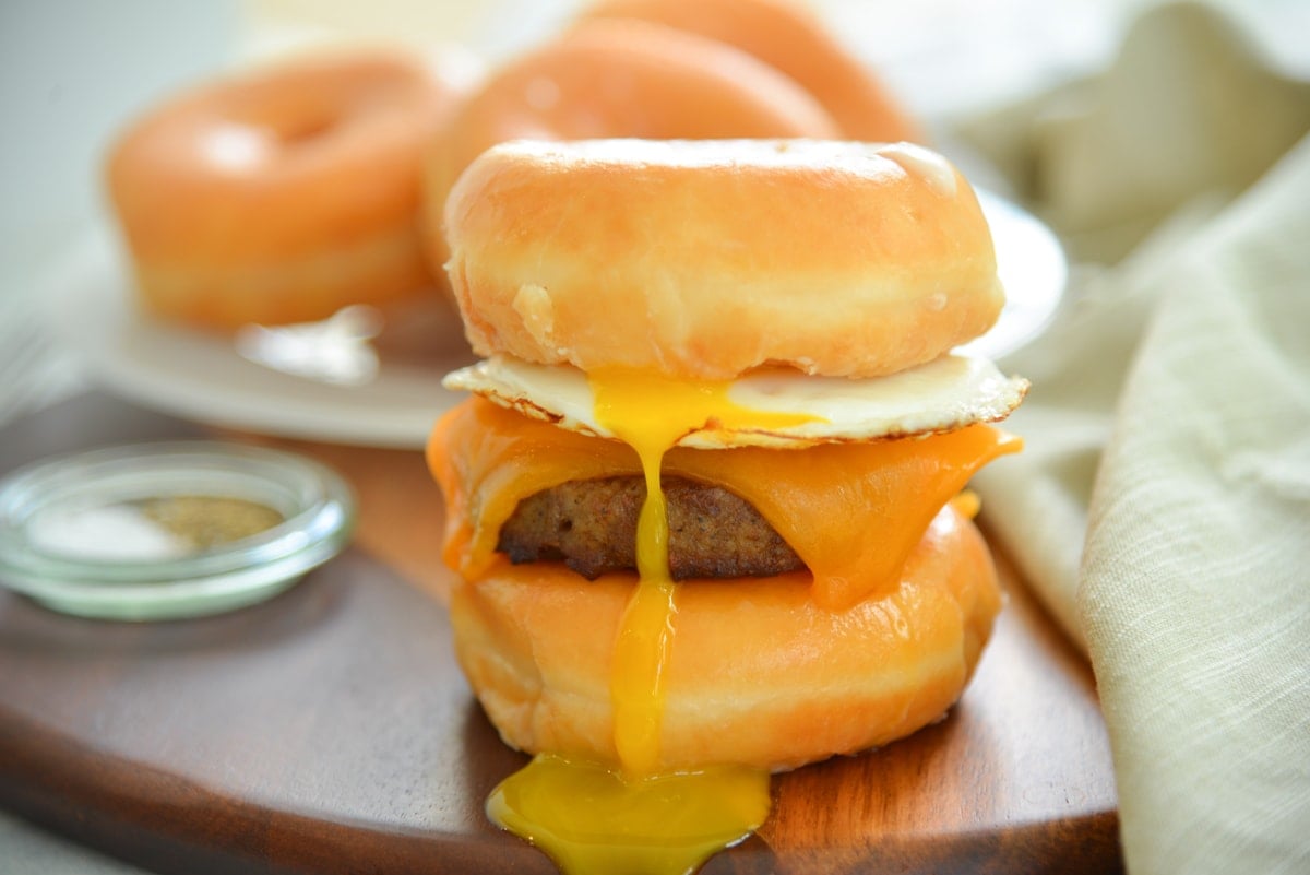 donut breakfast sandwich with drippy egg yolk