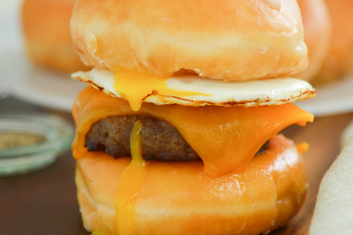 close up of egg yolk dripping down a breakfast sandwich  