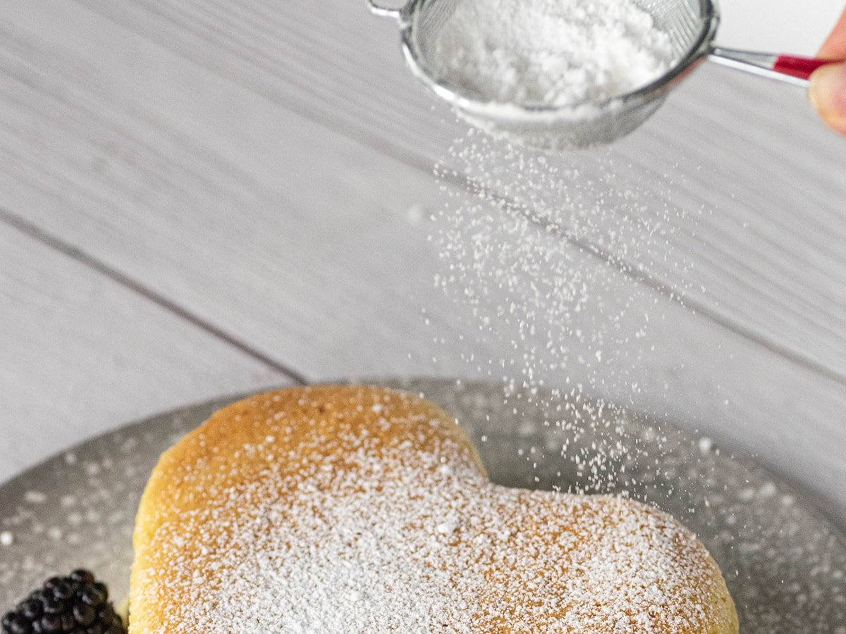 dusting powdered sugar onto cheesecake 