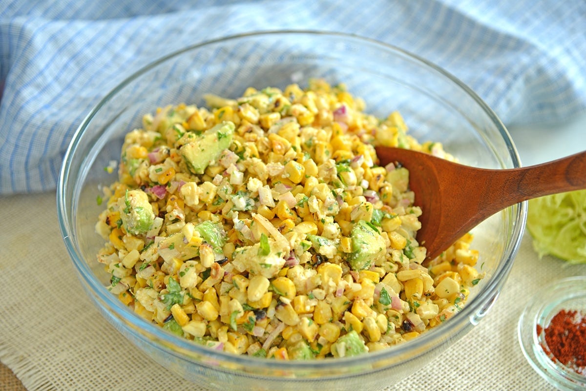 tossing corn salad ingredients 