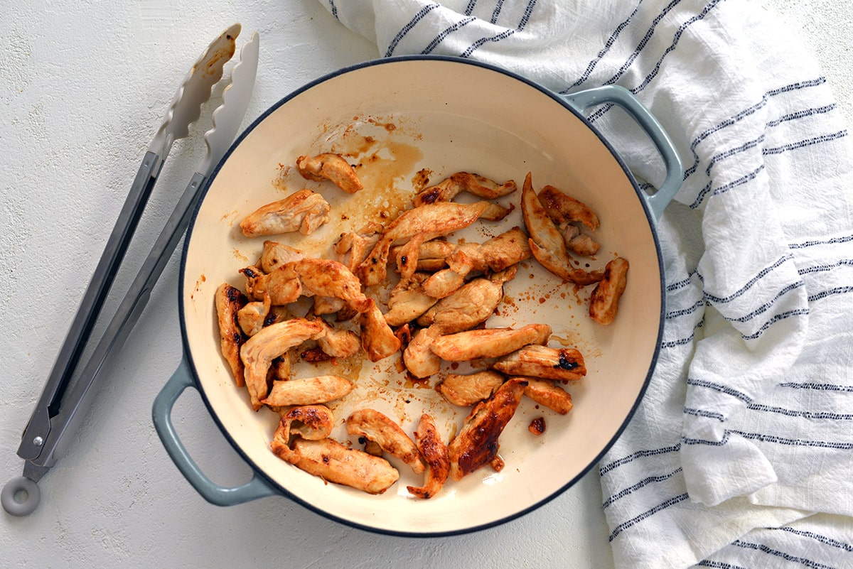 browned chicken in a cooking vessel 