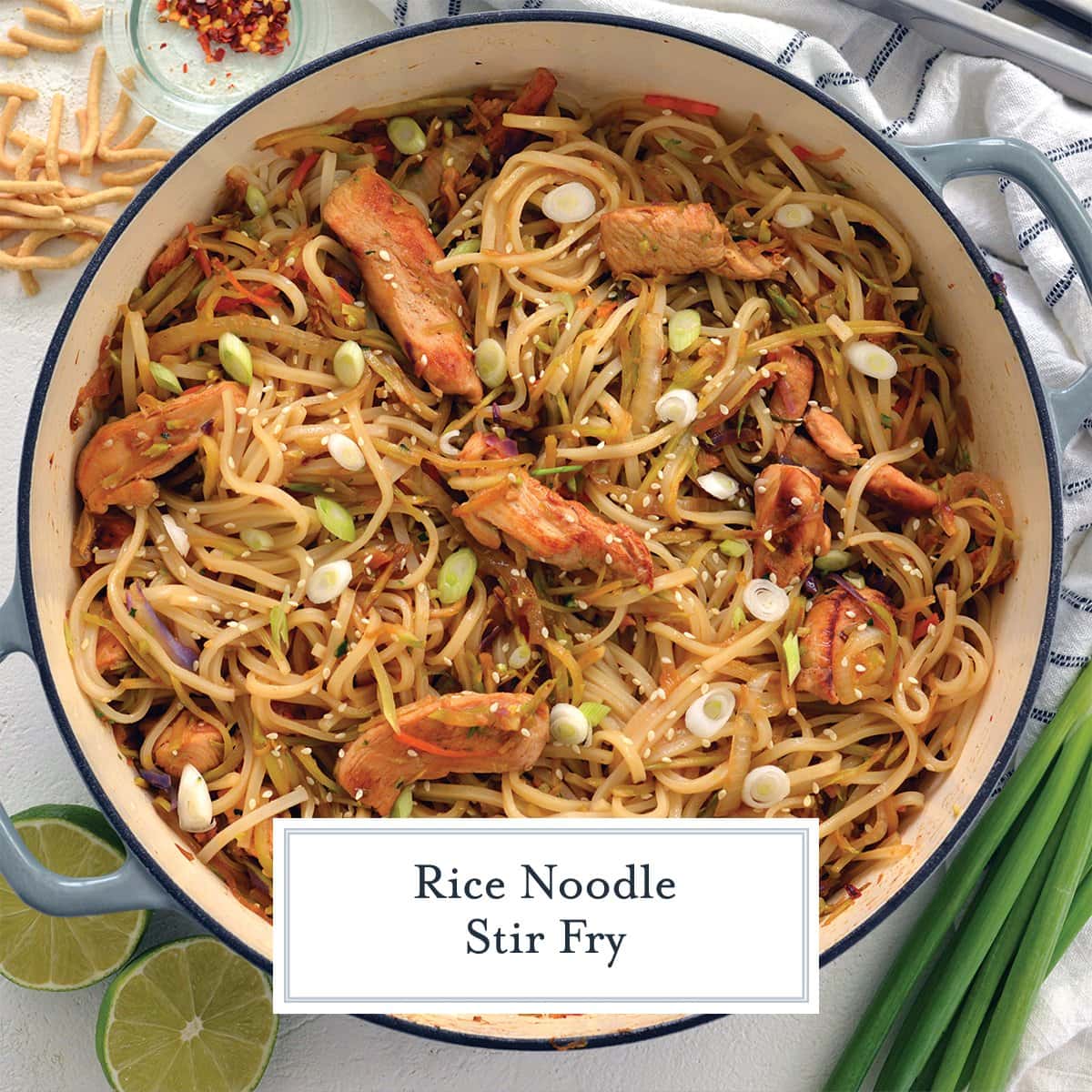 overhead of rice noodle stir fry in a blue cooking vessel 