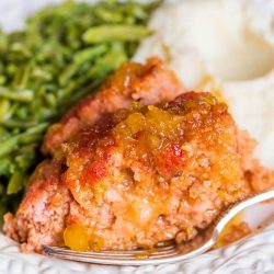 ham loaf with greens and mashed potatoes on plate