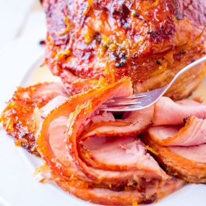 slices of honey baked ham with a fork