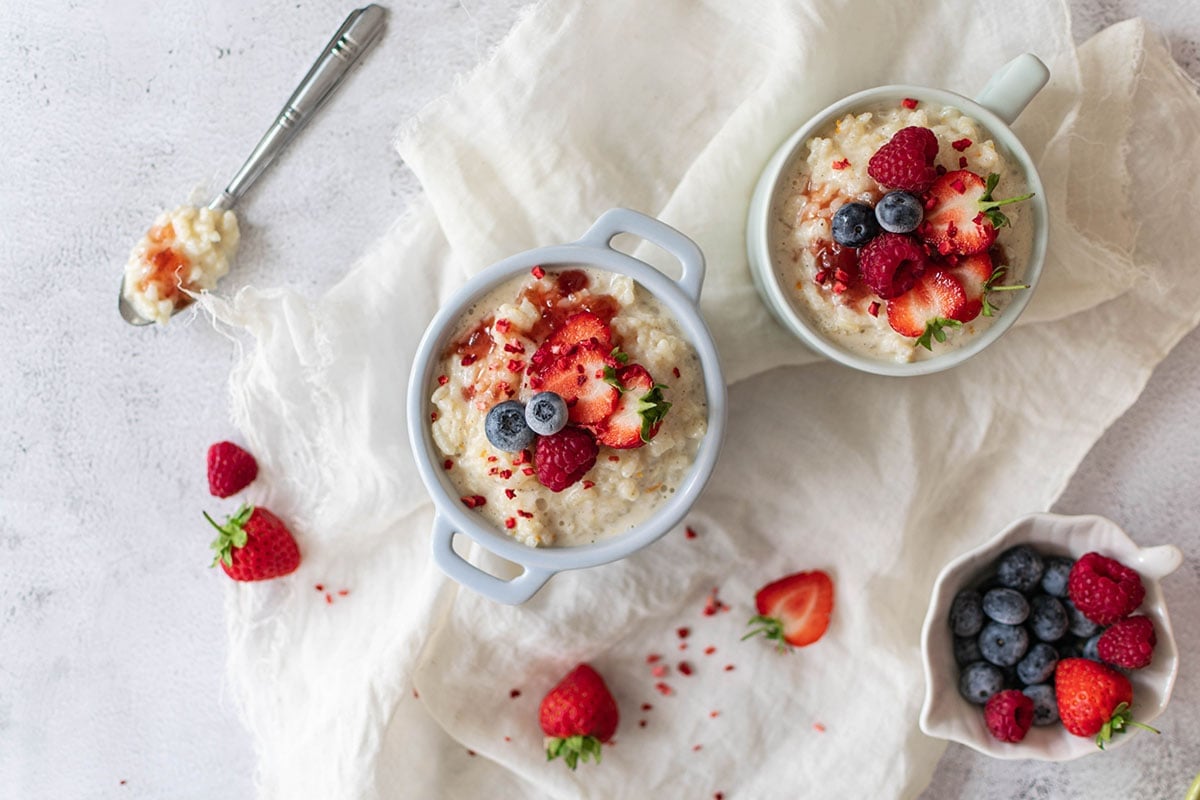 overhead of several serving bowls of rice pudding and fruit 