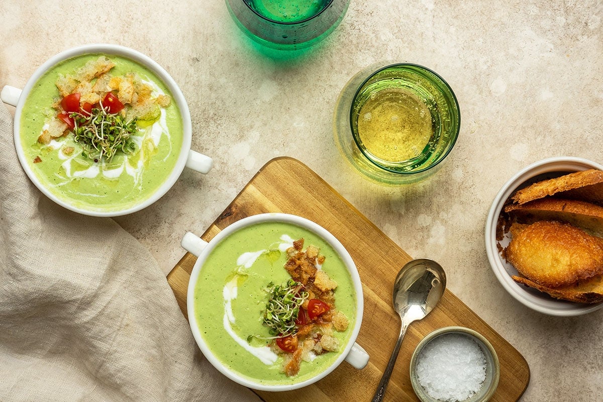 bowls of green gazpacho with wine and bread 