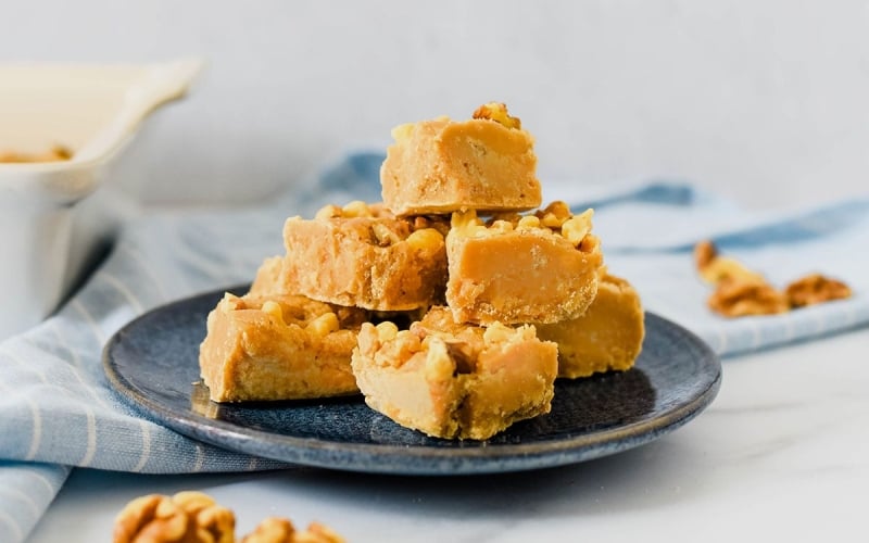 pile of maple walnut fudge on blue plate