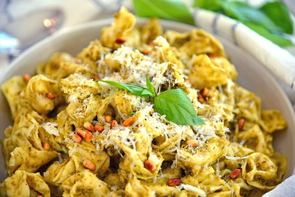 close up of pile of tortellini with asiago cheese and pine nuts 