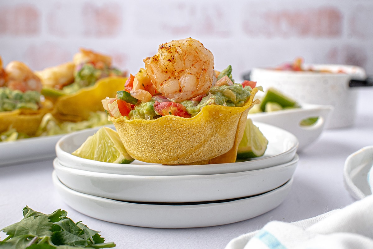 shrimp tostada cup on a tower of white plates 