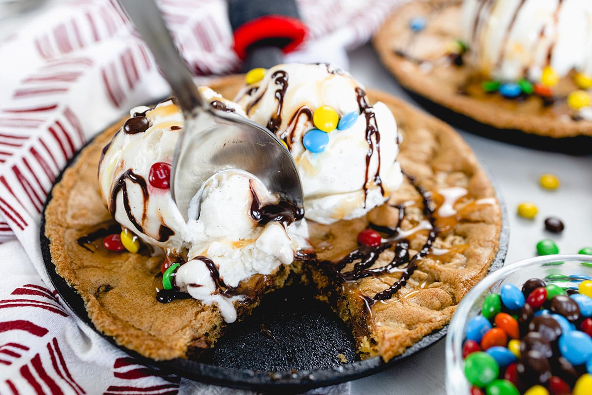 spoon digging into a skillet cookie 