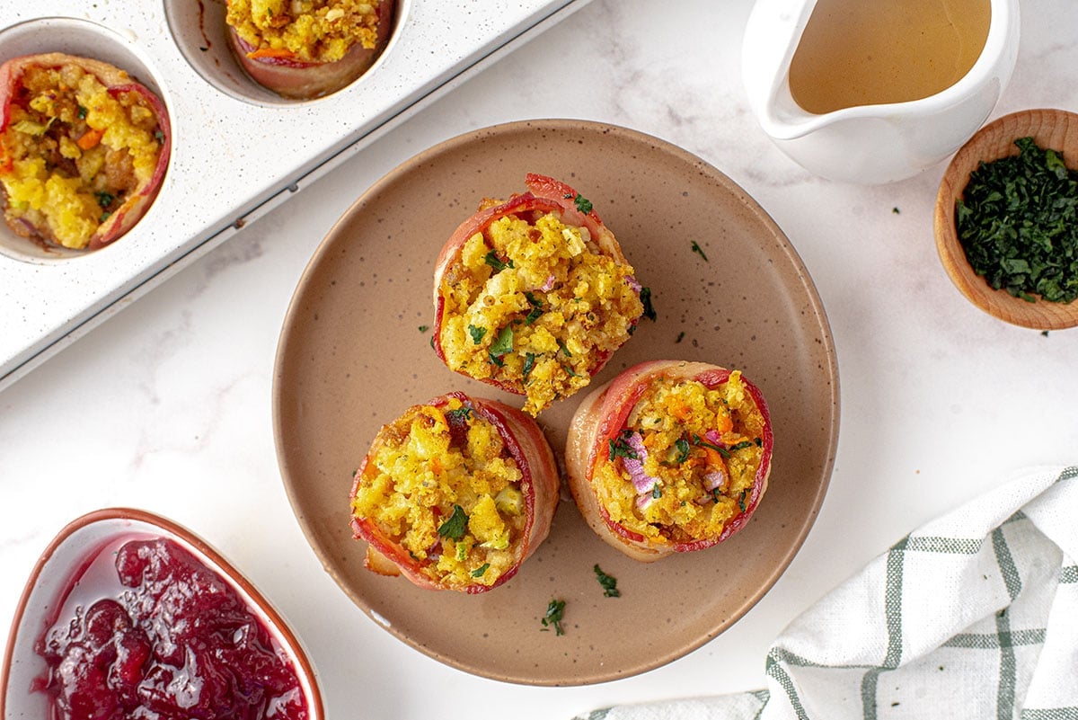 overhead of three stuffing muffins on a brown plate 