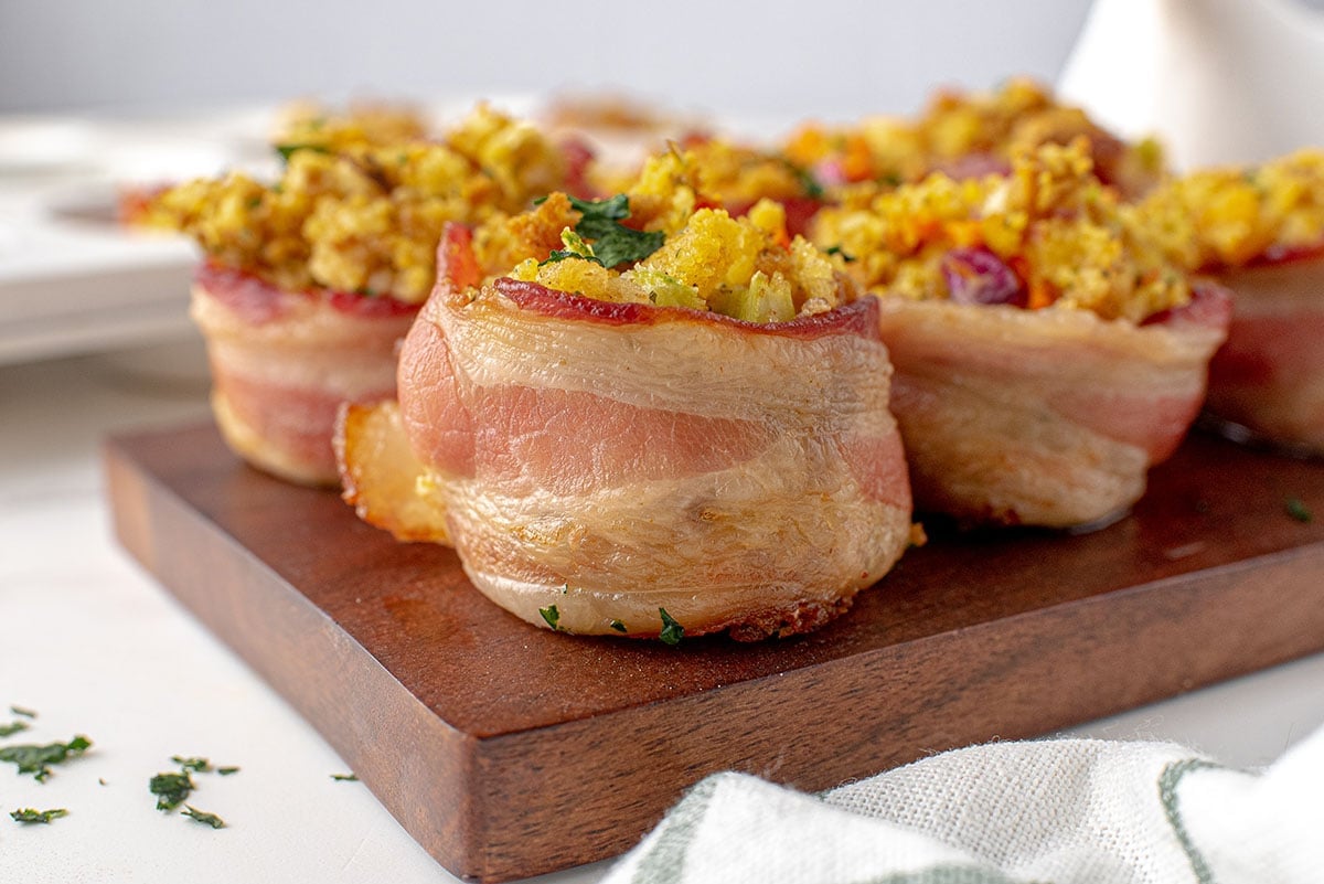 bacon wrapped stuffing muffin on a cutting board