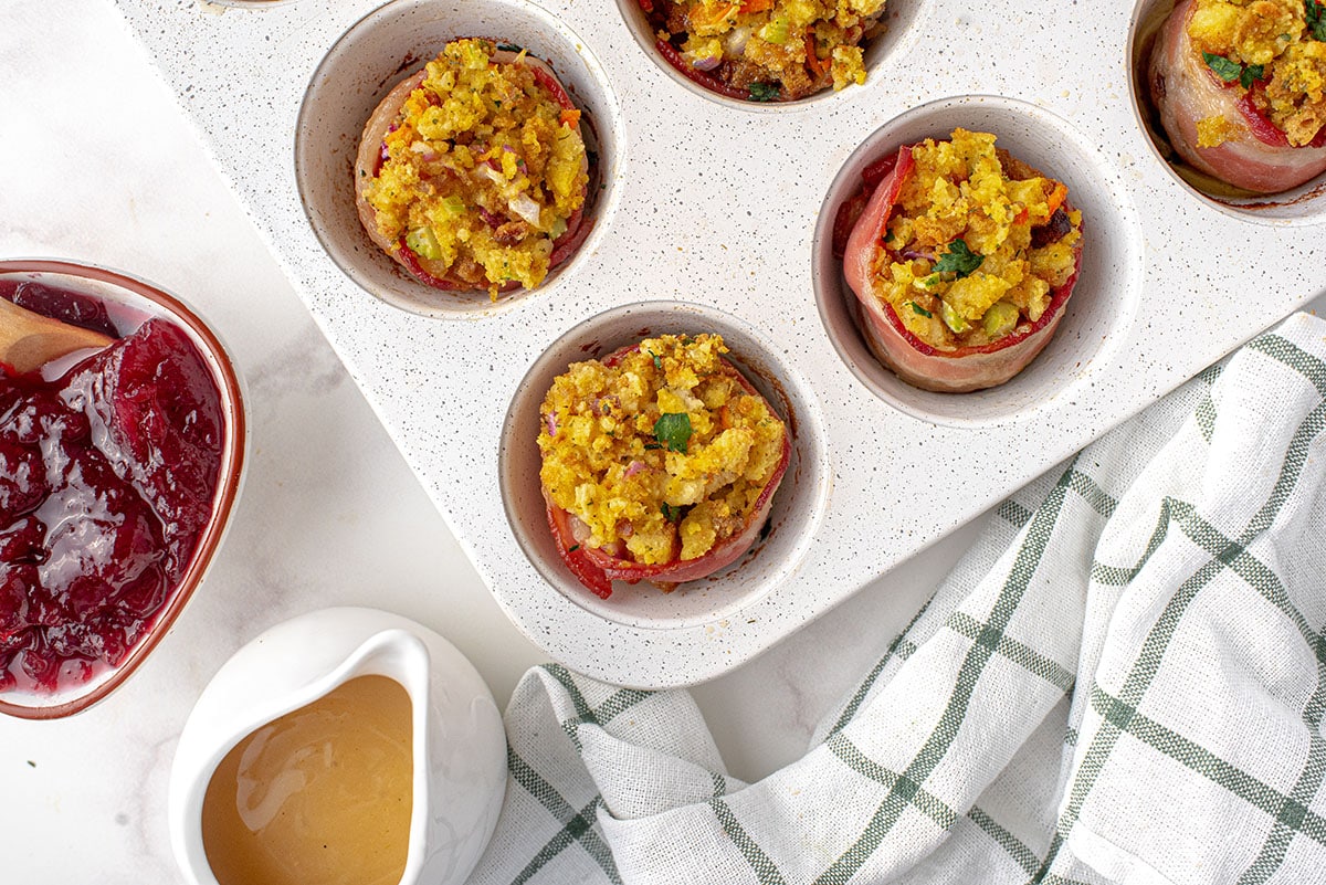 overhead of stuffing muffins in a tin with cranberry sauce and gravy