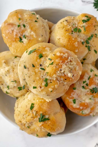 bowl of buttery garlic knots with marinara sauce