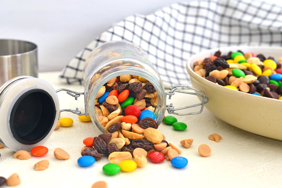 trail mix pouring out of a glass jar 