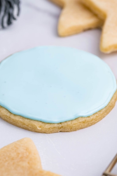 angled shot of rolled sugar cookie with blue icing