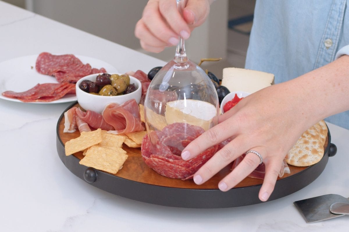 placing a meat rose on a charcuterie board 