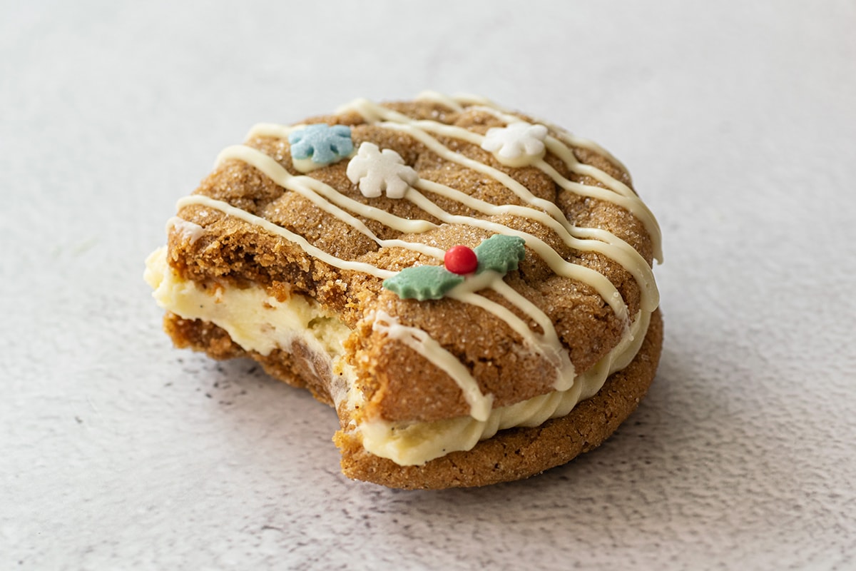 holiday decorated molasses cookie sandwich with a bite taken out of it 