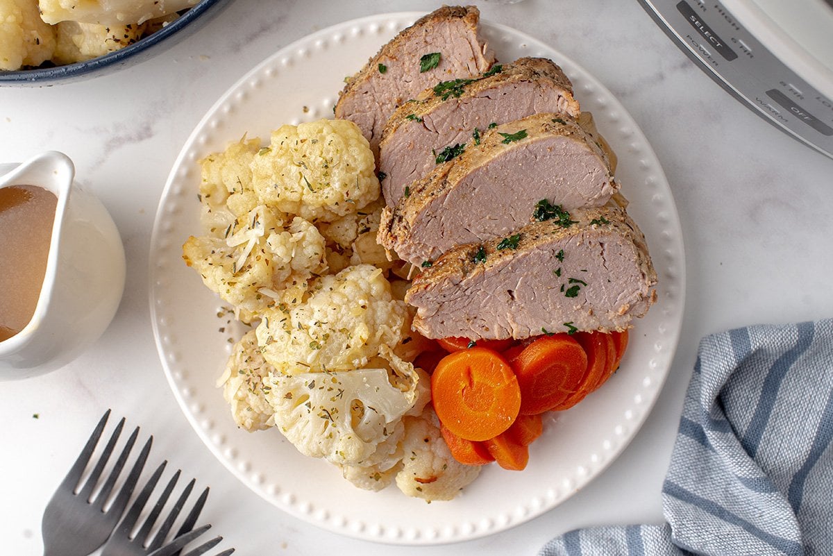 sliced pork on a plate with cauliflower 