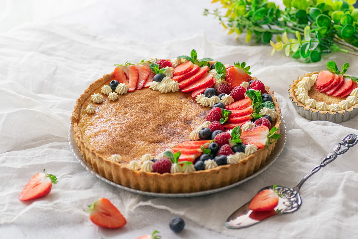 angle of creamy custard pie with fresh fruit 