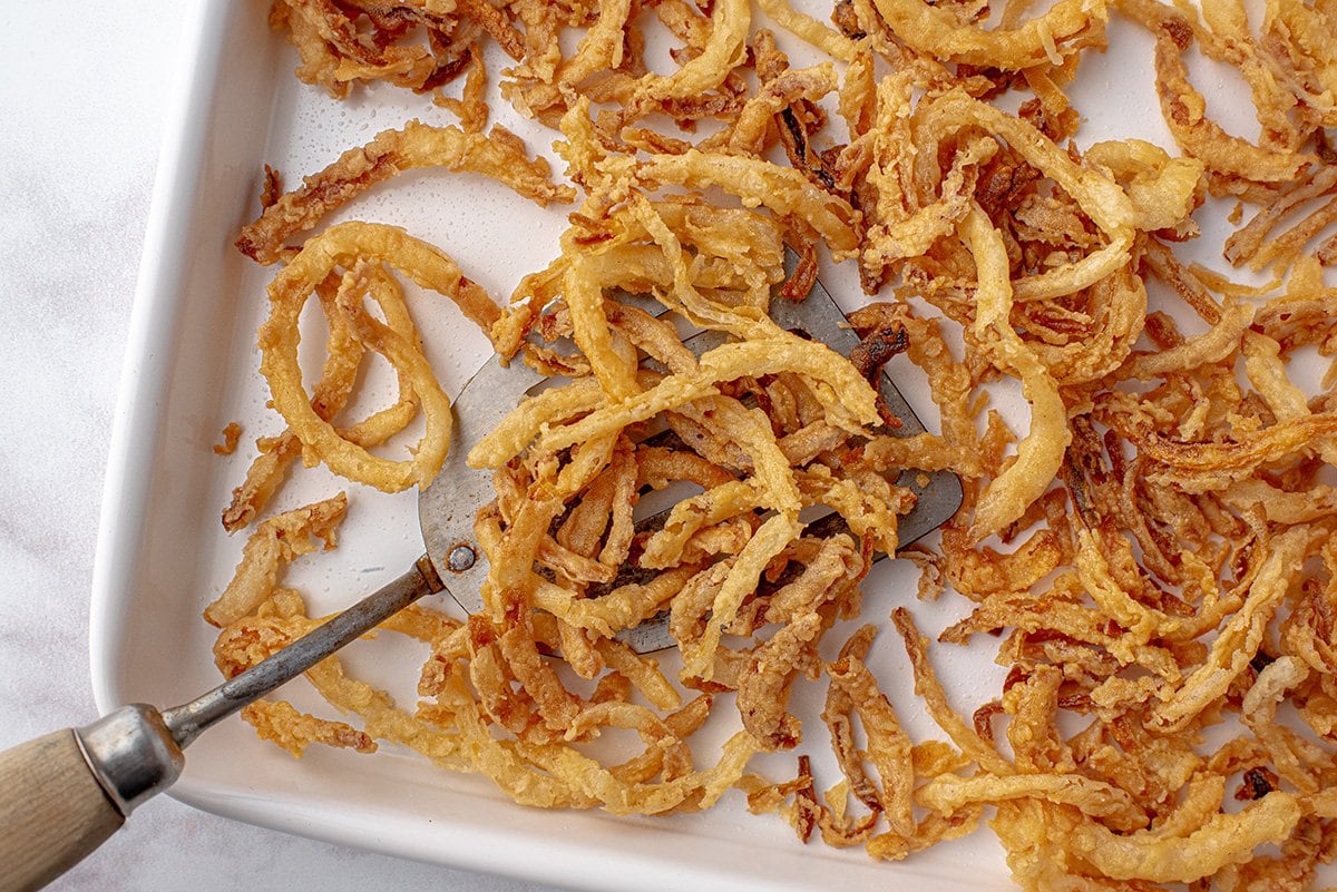 spatula lifting up french fried onions 