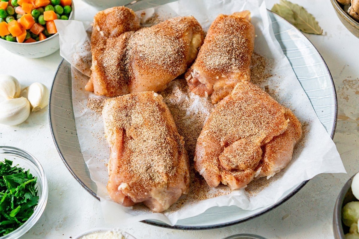 seasoned raw chicken thighs on a plate