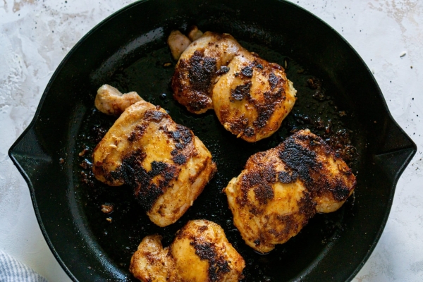 browned chicken thighs in a cast iron