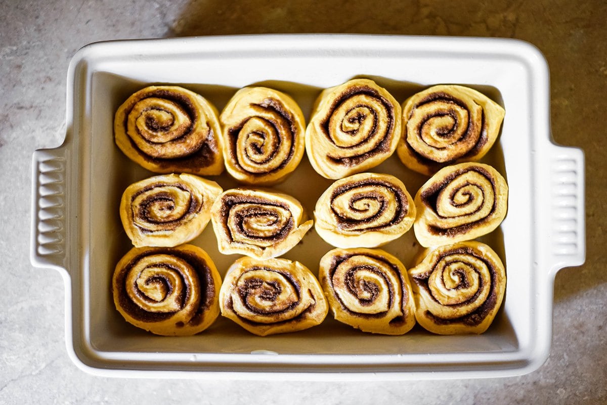 cinnamon rolls rising in baking dish
