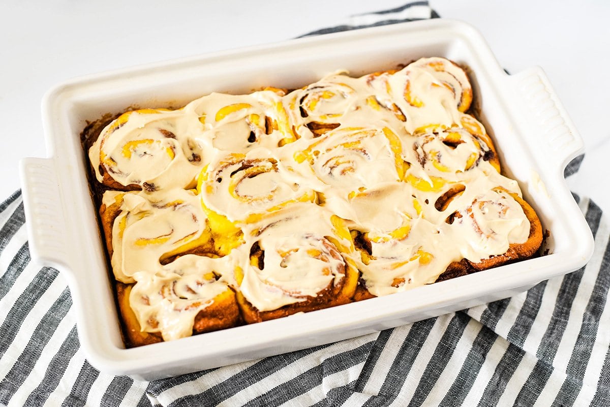 frosted cinnamon rolls in a baking dish 