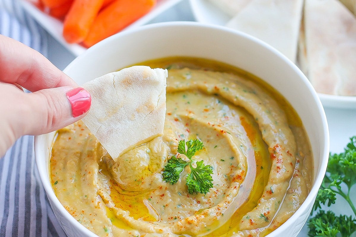 pita bread dipping into roasted eggplant dip 