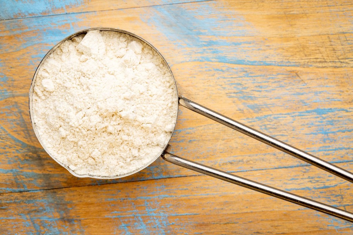 overhead of flour in a metal measuring cup 